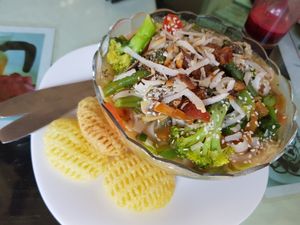 really good sweetish rice noodle bowl with cooked veggies and side chips (vegan and gluten free) at Aum Cafe in Varanasi