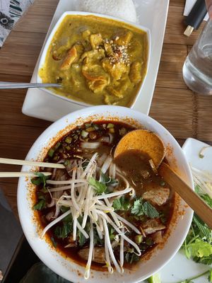 Vietnamese yellow curry and rice with crispy tofu on top, hot and spicy pho with vegan chickn on bottom  at Pho - Islington in North London