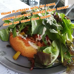 Vegan Flatbread with soy mince, caramelised bell peppers, fresh rocket salad and vegan sour cream. at Estrella in Paphos