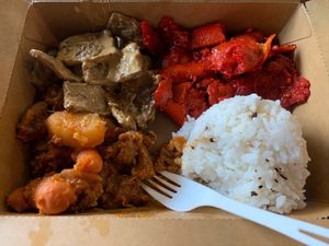Clockwise from bottom left: Kaldereta (Filipino style pot roast), Thai “beef” basil, mock pork, garlic rice. at Nick's On Mission in San Francisco