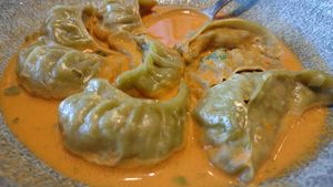 Veg Jhol Momos (dumplings filled with kale, butternut squash, mushrooms, and spices, served in a sauce made from cashews and peanuts – vegan, $14)  at Zomsa in El Cerrito