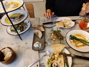 Hummus, baba ganoush and Lebanese salad (towered left) with the pita bread. Stuffed pita with dill mayo (center left), chili green beans (center) and broccolini's (right) at HUMM Restaurant in Antwerpen