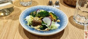 Hazelnut-crusted marinated tofu, grilled broccoli, hazelnut vinaigrette, yuzu peel, broccoli julienne with white balsamic, yuzu emulsion, nasturtium shoots at the friendly kitchen in Paris