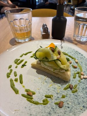 Pizza crust with soy ricotta, pesto w/ pine nuts, lemon marinated zucchini; NA lemon beer at the friendly kitchen in Paris