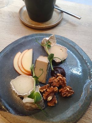 cheese board with bread, apple, walnuts, fig jam, blue, goat, and camembert at the friendly kitchen in Paris