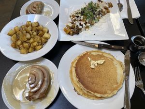 Cinnamon roll, classic pancakes, roasted potatoes and classic scramble   at Blossoming Lotus - Irvington in Portland