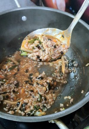 making porridge by adding the rice into leftover broth at Dotori Kalguksu in Seoul