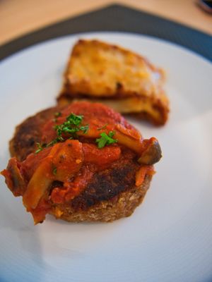 Hamburg Steak is topped with savoury tomato and mushroom sauce. at Upgrade Plant Based Kitchen in Osaka
