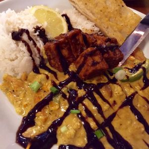 Lunch special, vegan option: Jerk tofu sprinkled with a mango-chocolate balsamic reduction, served with sautéed carrots, bell peppers, and onions in a Madras coconut curry sauce, on top of basmati rice.  at Nine Mile Montford in Asheville