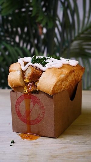 SANDWICH DE REVUELTO Y POLLO FRITO: Toasted brioche bread, scrambled WEVOs (vegan eggs), fried chicken, sweet chili sauce, mayo, sesame seeds, and chives. at Frutas Prohibidas in Madrid