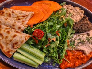 Mezza Platter with house made hummus, red pepper compote, baba ghanoush, olive tapenade, arugula salad and veg and pita VEGAN at Fernwood Bar & Grill in Big Sur