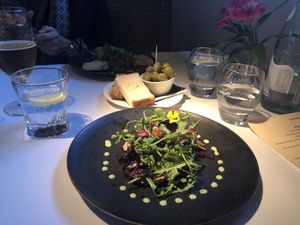  Marinated aubergine with green tahini dressing. Side of olives and gluten free sourdough. at Fellinis in Ambleside