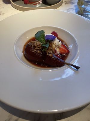 Poached pear in red wine sauce with vegan ice cream  at Fellinis in Ambleside