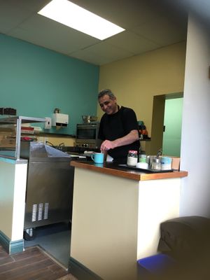 Bassam pouring coffee - goes so well with the Cosmic Cookie. Try to guess the secret ingredient.  at The Good Lands Cafe in Winnipeg