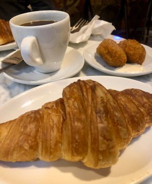 Croissant and coffee, with a couple of croquettes on the side.  at The Vegan Corner in Barcelona