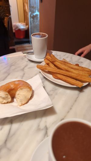 Hot chocolate with oat milk, part of the donut, and 6 churros. at The Vegan Corner in Barcelona