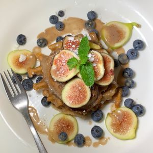 Polenta & Fig Waffles w/ Fresh Green & Black Figs, Blueberries, Cashew Cheeze, Mint, Fennel Sauce at Juice By J in Grand Rapids