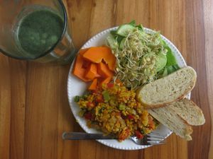 Breakfast made of vegan "scrambled eggs", sourdough bred, fresh salad and papaya at Lulo's Restaurante in Jardin