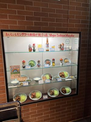 Window at front of store showing some menu options  at Izakaya Masaka in Tokyo