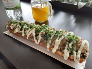 Zapiekanka with mushrooms, vegan cheese, chives, onions + garlic mayo at Wat Kam Chu in Gdynia