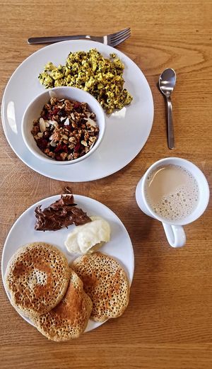 Tofu brouillé, granola, pâte à tartiner, beurre de pomme, pancakes et chaï latte at Comme une Poule in Toulouse