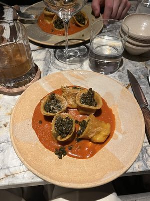 tortelloni with Preserved lemon plant-based ricotta, tomato sauce, wild pesto, crispy capers & tarragon oil  at MESA Restaurant in Paris