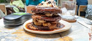 Purple Corn Pancakes with Hoy vanilla yogurt, roasted almond butter, banana, toasted coconut chips & yacon syrup at MESA Restaurant in Paris
