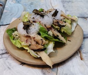 An amuse bouche of cold mushrooms on lettuce at MESA Restaurant in Paris