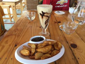 Potato wedges and delicious vegan cold coconut coffee  at Yogi's in Auroville