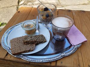 Wholemeal bread with carrot spread, overnight oats, and hot chocolate with oat milk at Palais Café in Dresden