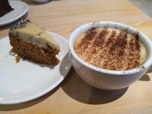 Carrot cake and oat milk cappuccino at The Quirk Space in Olney