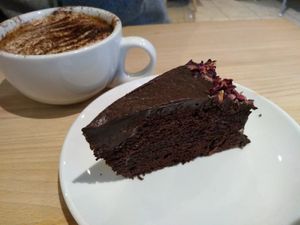 Chocolate cake with almond milk cappuccino at The Quirk Space in Olney