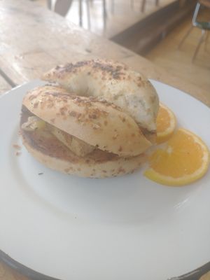 Tofu breakfast sandwich with vegan cheese, garlic spread on an onion bagel at Paradigm Coffee & Music in Sheboygan