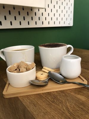 Americano with oat milk, oat milk cappuccino plus two mini biscuits   at Mr Cooper's Coffee House in Whitby