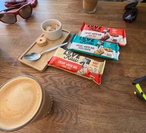 Oat flat white, served with sugar cubes and mini jammie dodgers. Three varieties of LoveRaw wafer bars. at Mr Cooper's Coffee House in Whitby
