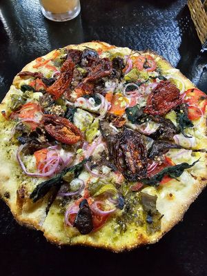 Pesto Pizza with sundried tomatoes, onion, eggplant, spinach and vegan cheese. Small size. at Minuteman Pizza in Uyuni