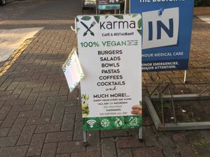 Karma sidewalk sign with some menu items  at Karma in Jaco