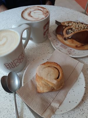 Drinks: The Buddy and Praline Chocolate, Food: Vegan Cinnamon Roll and Peanut Butter Donut at Buddy Buddy in Brussels