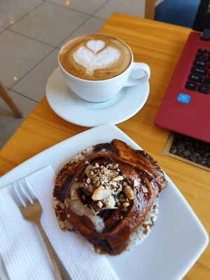 Almond milk latte and hot cinnamon roll - so good!! at Café Monteverde in Monteverde