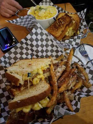 In the foreground, the Vegan Mac Daddy Patty Melt: A Beyond burger on grilled sourdough with caramelized onions, melted mozzarella, BBQ sauce and vegan macaroni and cheese. Served  at The Point in Bend