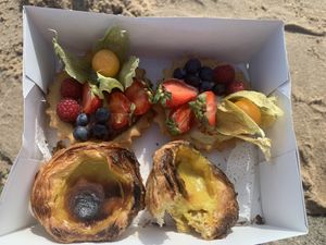 Take away nata and fruit tart for a trat at the beach    at Odete Bakery in Porto