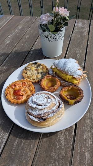 Two types of quiche, pastel de nata, Berliner, and a cinnamon roll. at Odete Bakery in Porto