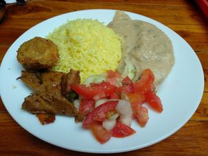 Rice, polenta, marinated seitan, delicious deep-fried carrot ball and salad. at Govinda Gopal - Govindas  in Quito
