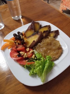 Bean vegan burger, sweet potato and salad ( tomato, lettuce, garlic bits, olives red sliced peppers and peanuts with a balsamic glaze...caramelized onions on top of burger.... at Vegan Box in Faro