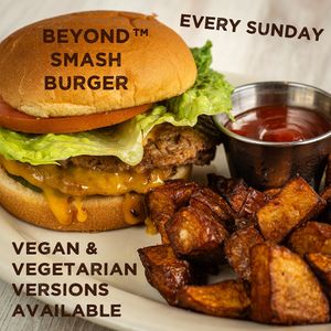 Two Beyond™ patties, 🧅 caramelized onions, 🧀 cheddar cheese, secret burger sauce, 🥬 lettuce, 🥒 pickles, and 🍅 tomato on a toasted bun served with homemade chunky f at Dangerous Minds Brewing Co in Pompano Beach