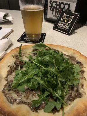 Under all that arugula is an amazing creamy mushroom pizza with Violife! 😍 at Dangerous Minds Brewing Co in Pompano Beach