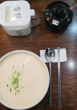 Summer special: Serving of vegan Kong-guksu (콩국수) and containers with salt and sugar for individual seasoning at Saenggak Boda Masitneun Jip in Seoul