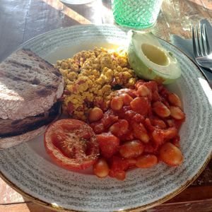 Vegan English breakfast with baked beans, a grilled tomato, scrambled tofu, bread and half an avocado at Natural Kitchen in East London