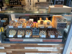 Pretzel selection - 3 of the bottom row are vegan (the 1 to the left of the sign & the 2 to the right) at Knot Artisan Coffee & Pretzels - Victoria in South West London