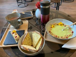 zucchini soup with bread (half portion already eaten), almond pastry (already eaten half), cup with hot chocolate at Be Nuts in Brussels